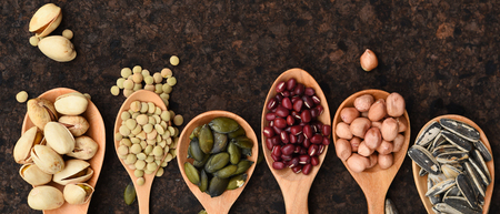 Assortment of beans and lentils in wooden spoon on teak wood backgroundの写真素材