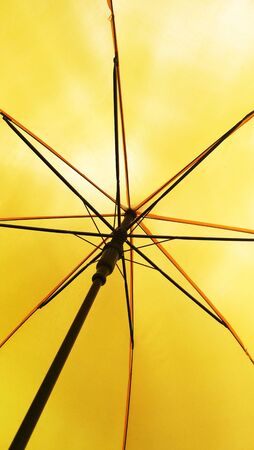 close up of under a yellow umbrella of its metal framesの写真素材