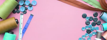 Composition with threads and sewing accessories on pink background