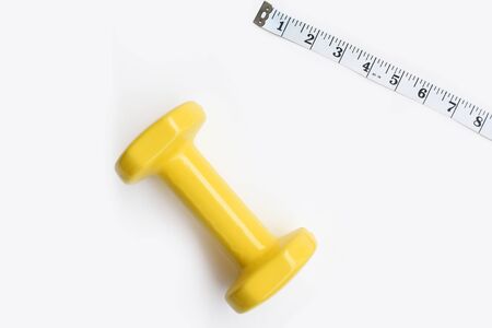 Fitness concept dumbbell and measuring tape isolated on white backgroundの写真素材