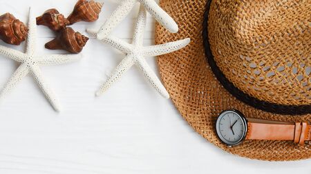 Summer straw hat and starfish on white wooden background
