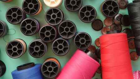 Composition with threads and sewing accessories on green background