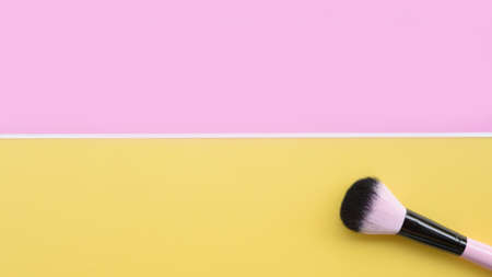 close up of makeup brushes on pink and yellow backgroundの写真素材