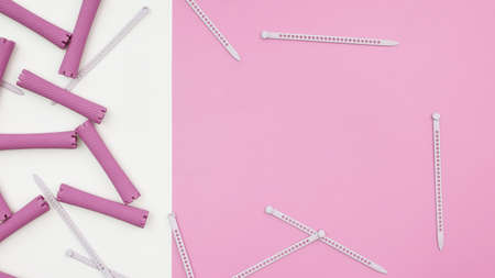 close up of hair curlers on pink and white background