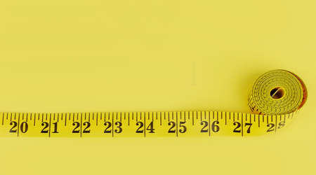 close up of measure tape on yellow backgroundの写真素材