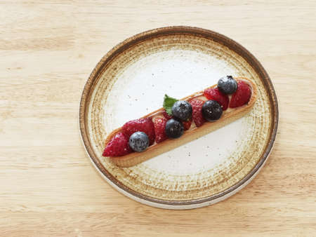 Homemade strawberry and blueberry cheesecake for dessert on plateの写真素材