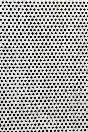 Close up metal plate with many small circular holes for backgroundの写真素材