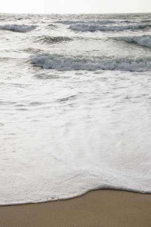 Wave of the sea on the sand beachの写真素材