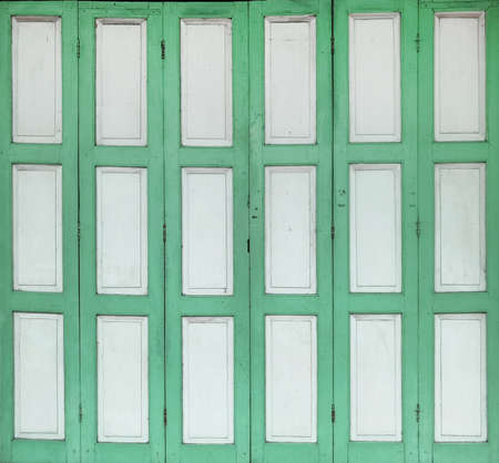 Old rustic wooden doors painted in white and green.の写真素材