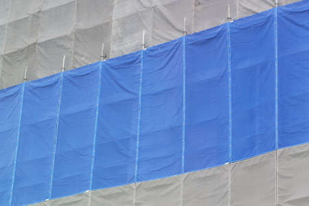Building under construction wrapped blue protection safety netの写真素材