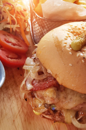 Hamburger with cheese and fried potatoes on a wooden tableの写真素材