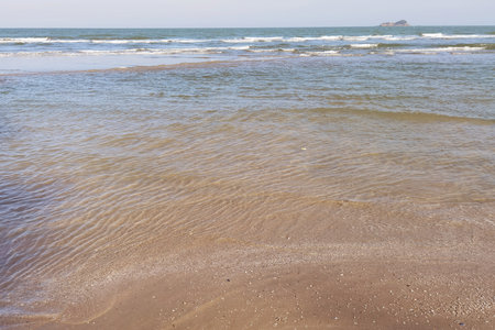 Wave of the sea on the sand beachの写真素材