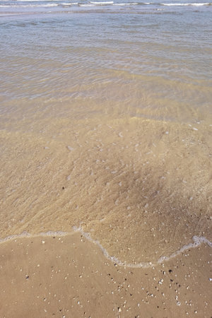 Wave of the sea on the sand beachの写真素材