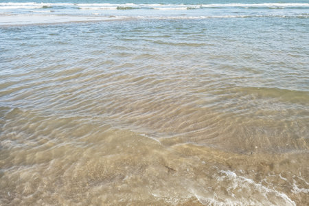 Wave of the sea on the sand beachの写真素材