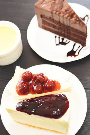 A delicious slice of chocolate cake and cheesecake with fruit topping.の写真素材