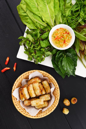 Fried spring rolls with sweet chili sauce on a woven basketの写真素材