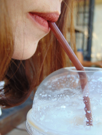Beautiful women are sucking the coffee from the glass of coffee.の写真素材