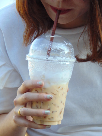 Beautiful women are sucking the coffee from the glass of coffee.の写真素材