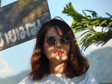 Beautiful woman stands under the tree and sings the sun shine.の写真素材