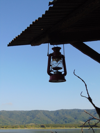 Glass lamp hangs under the zinc roof.の写真素材