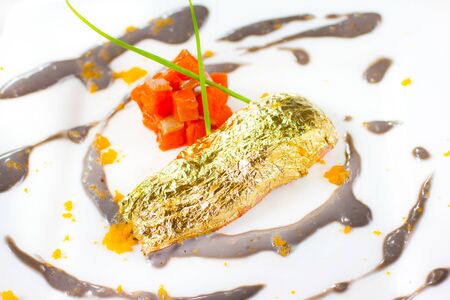 sea food   roasted wild salmon , gold sauce on white dishの写真素材