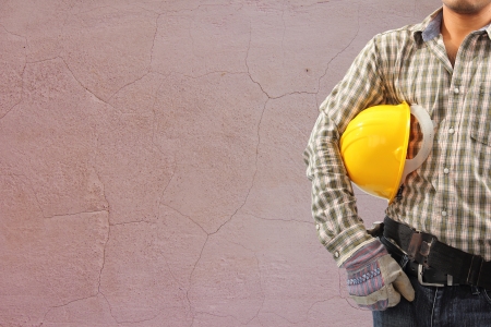 Worker and the cracked concrete vintage brick wall backgroundの写真素材