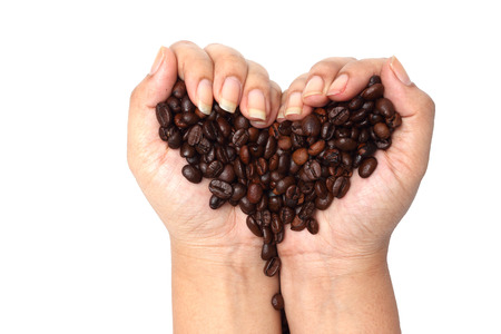 coffee beans in hand on shape heart with clipping pathの写真素材