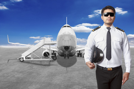 Pilot airplane in front of movable boarding ramp near the entrance to the passenger airplane