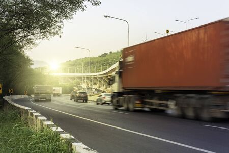 Truck with space for text driving fast on the countryside road with mountain against sunriseの写真素材