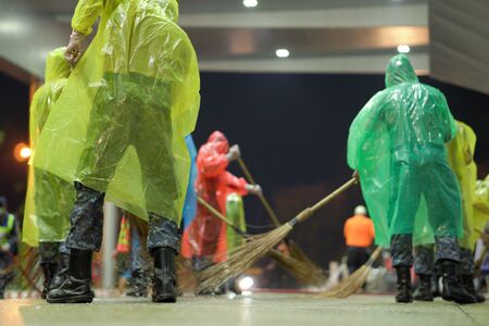 solders wearing rain cover, mask, glove, and plastic shield cleaning airport area to protect corona virusの写真素材