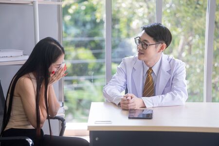 The psychiatrist is advising stressful asian female patients.の写真素材
