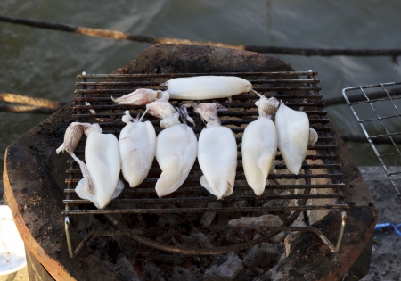 Cooking squid on the grill on the antique stove.の写真素材