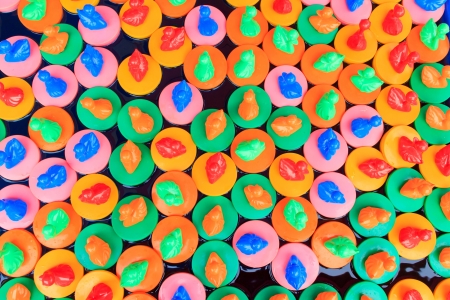 Many colorful rubber ducks floating in water.