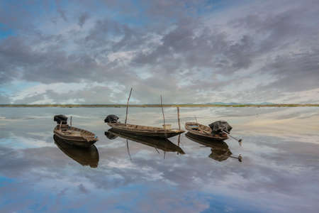 Boat parked shiny sky cloud water reflection.の写真素材