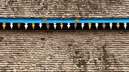 Yellow flower pattern in the blue bar on the wooden roof. Old house in Thailand.の写真素材