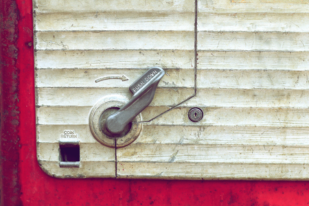 coin return slot on retro vending machine backgroundの写真素材