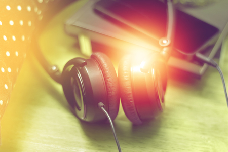 headphones with notebook and smartphone on wood floor, rest with music.の写真素材