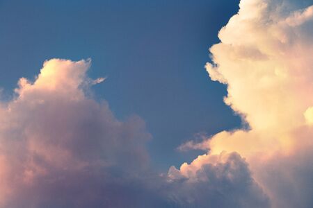 detail of white clouds and blue sky in orange sunset light
の写真素材