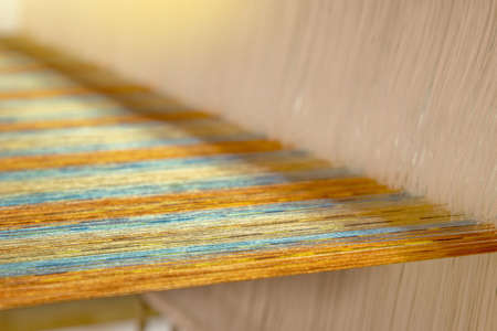 closeup of multicolour yarn on loom, abstract fabric weaving backgroundの写真素材
