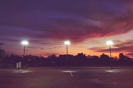 silhouette of outdoor light pole in empty local sport park with dramatic sky in the sunrise morningの写真素材