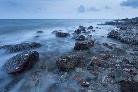 Waves hit the rocks at dawn の写真素材