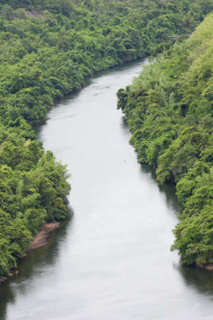 The river flows from the dam into the community の写真素材