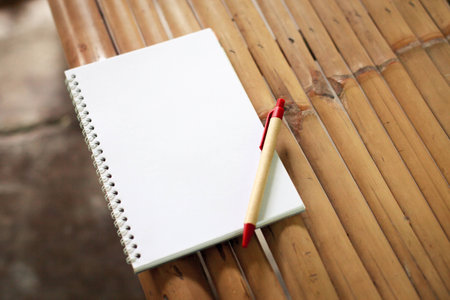 Open notebook on a table made ​​of Bamboo.の写真素材