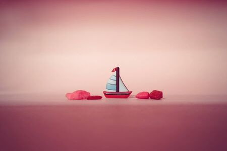 The tiny read sailboat on pink backgroundの写真素材