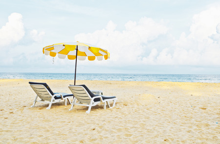Beach chair and umbrella on sand beach