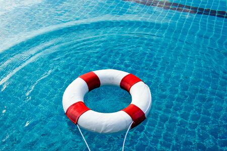Safety equipment, Life buoy or rescue buoy floating on swimming pool to rescue people from drowning man.の写真素材