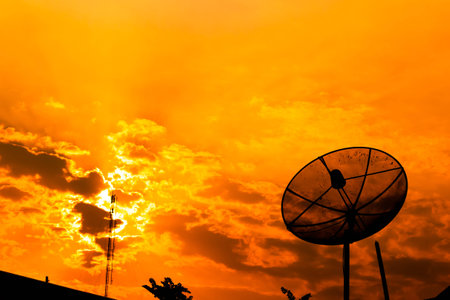 Satellite dish with  orange skyの写真素材