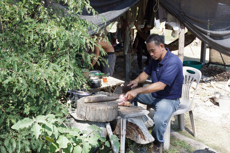 chef is sitting on a chair and cooking.Mahasarakham,Thailand,November 2016のeditorial素材