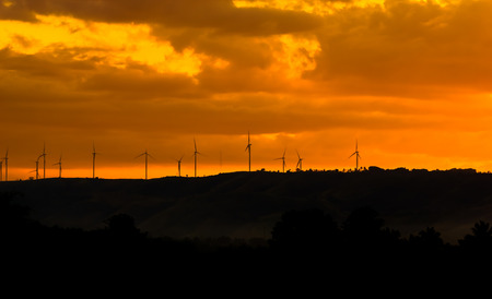 Wind turbines for electricity on a mountain at sunset.の写真素材