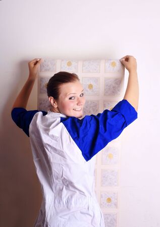 young woman tries on wall-papers to wall の写真素材